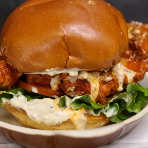 Big Dogs' spicy chicken sandwich with lettuce, tomato, and creamy sauce on a brioche bun.